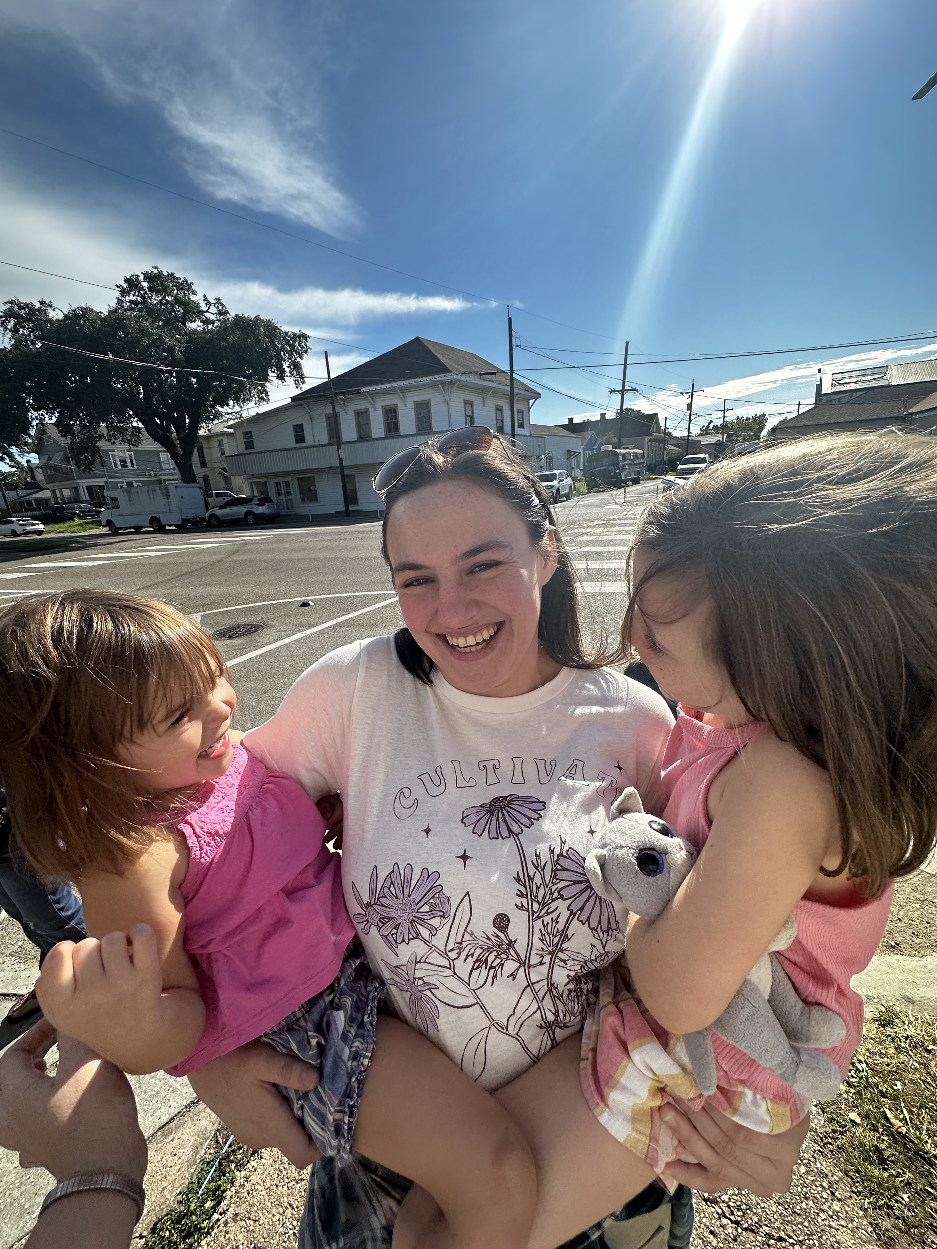 Gracey smiling while holding two children